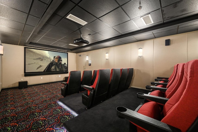 carpeted home theater with a drop ceiling