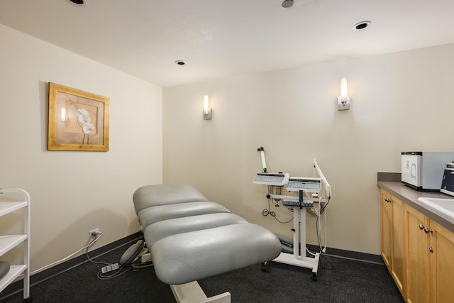 exercise room featuring dark carpet