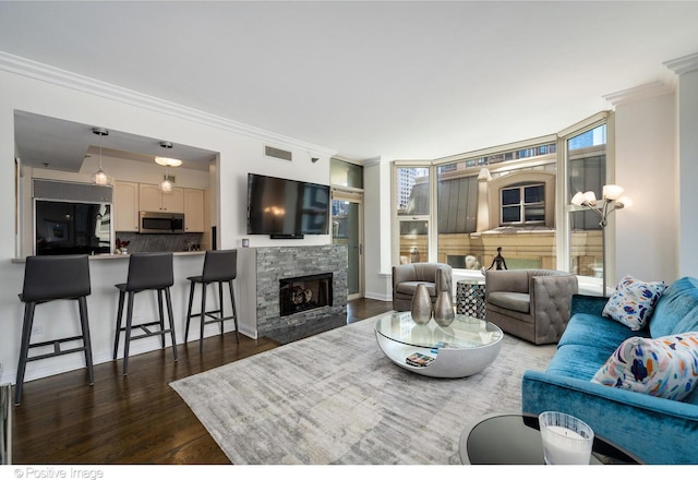 living room featuring a fireplace, ornamental molding, and dark hardwood / wood-style floors