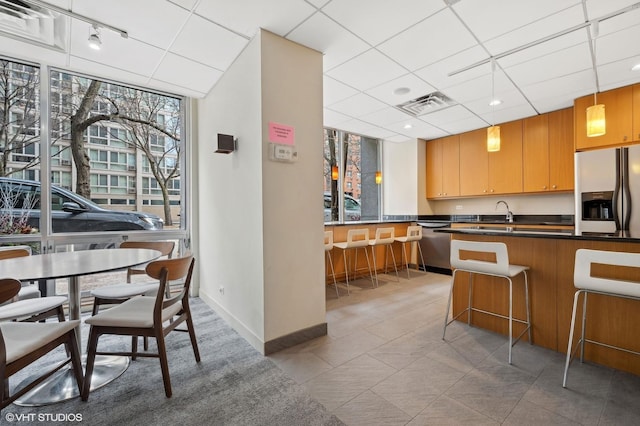 kitchen featuring sink, a breakfast bar area, a paneled ceiling, kitchen peninsula, and stainless steel appliances