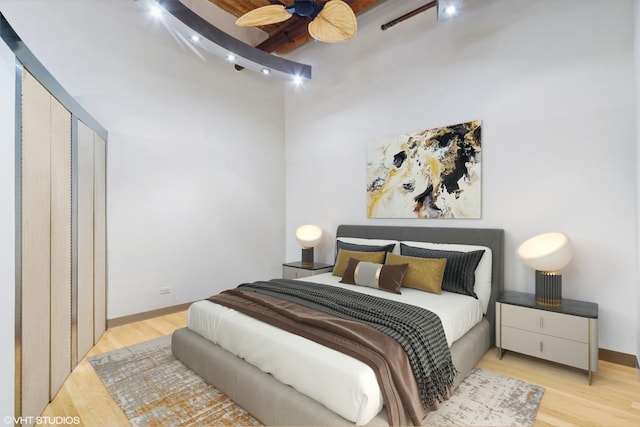 bedroom featuring beamed ceiling and light hardwood / wood-style flooring