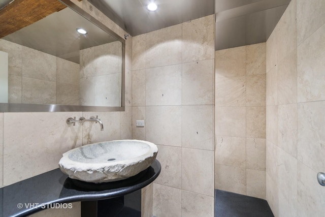 bathroom featuring sink and tile walls