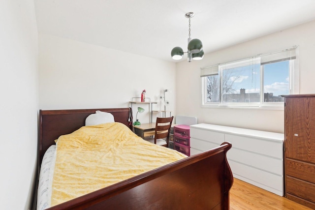 bedroom featuring a chandelier and light wood finished floors