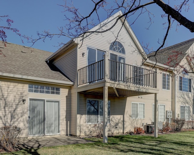 back of house featuring a balcony, a yard, and cooling unit