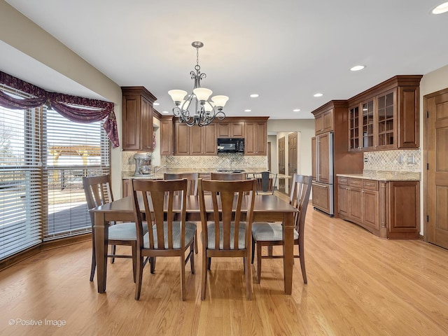 dining room with a notable chandelier and light wood-type flooring