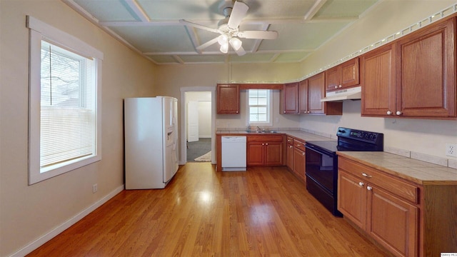 kitchen with coffered ceiling, white appliances, tile countertops, ceiling fan, and light hardwood / wood-style floors