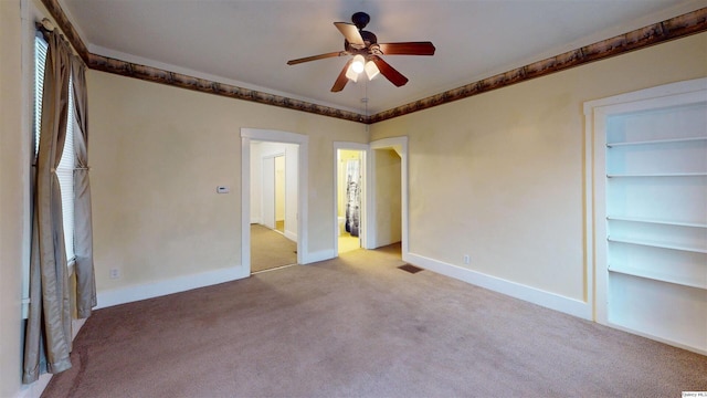 unfurnished bedroom featuring crown molding, light colored carpet, and ceiling fan