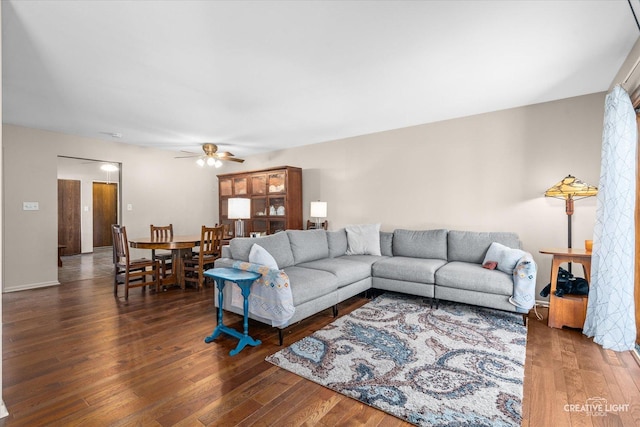 living room with dark wood-type flooring and ceiling fan