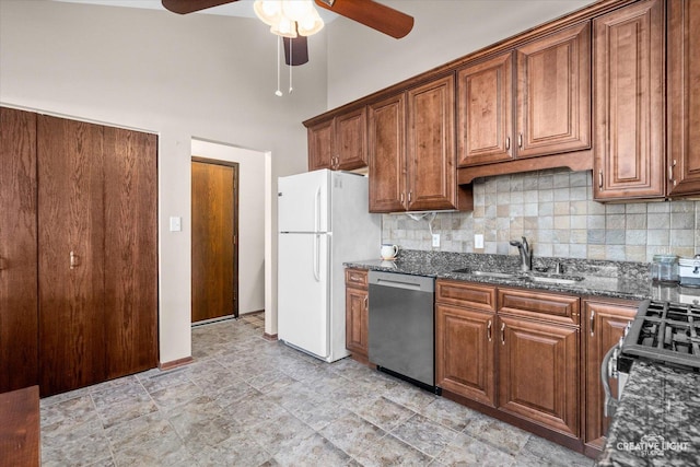 kitchen featuring appliances with stainless steel finishes, sink, dark stone counters, and backsplash