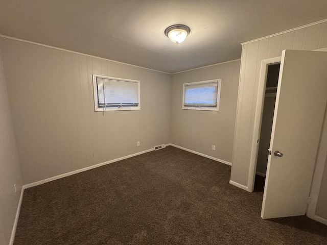 unfurnished bedroom with dark carpet