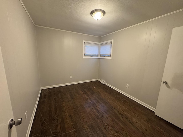 empty room featuring crown molding, dark wood-type flooring, and a textured ceiling