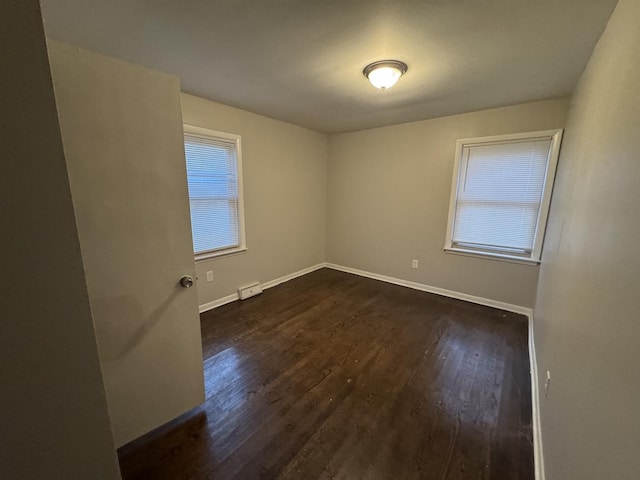 spare room featuring dark hardwood / wood-style flooring