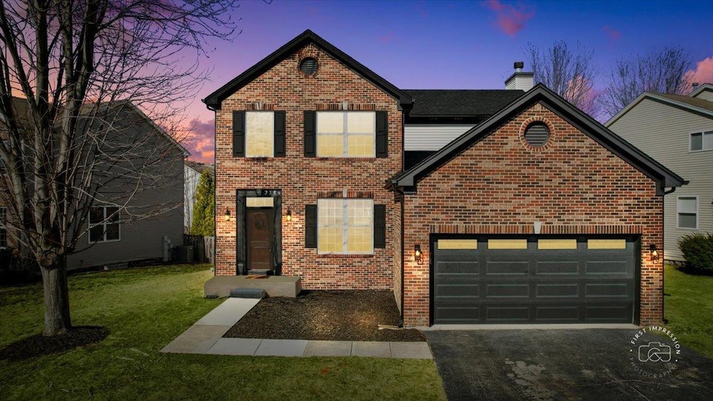 2384 Shiloh Dr, Aurora, IL 60503 - traditional-style home with aphalt driveway, brick siding, and an attached garage