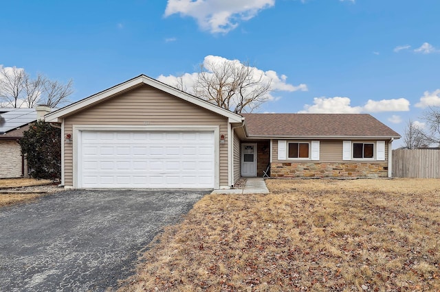 ranch-style house with aphalt driveway, a garage, a shingled roof, fence, and stone siding