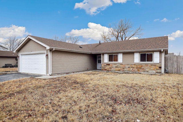 single story home featuring a garage, a shingled roof, fence, stone siding, and a front yard