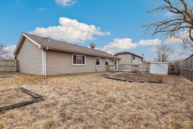 rear view of house with a storage shed and a fenced backyard