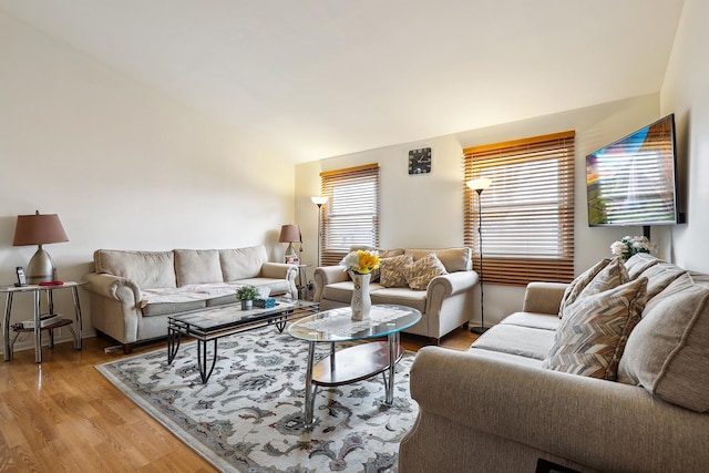 living area with vaulted ceiling and light wood-type flooring