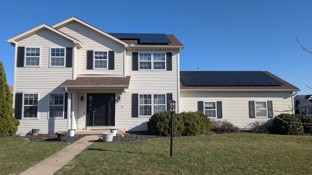 3902 Englewood Dr, Champaign, IL 61822 - view of front facade featuring a front lawn, solar panels, and roof with shingles