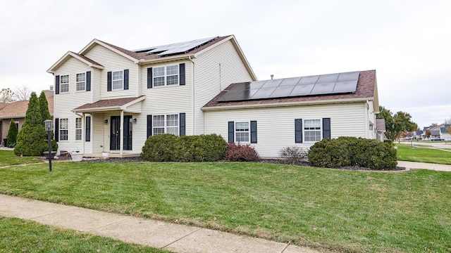 view of front facade with a front yard and solar panels