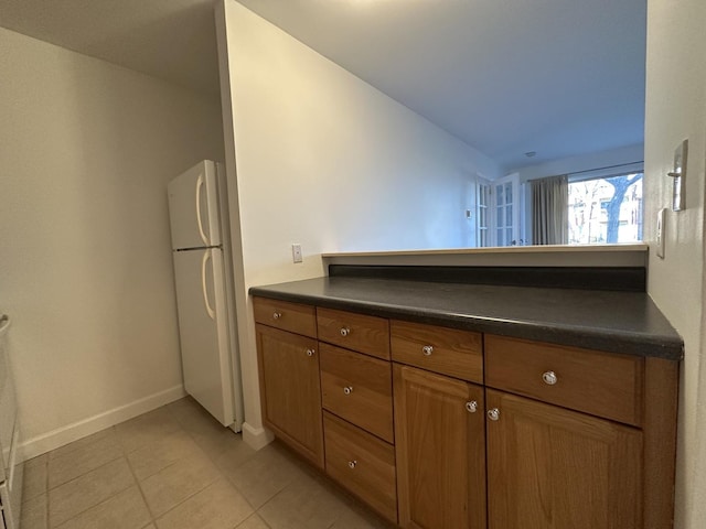 kitchen featuring white refrigerator and light tile patterned flooring