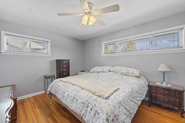 bedroom featuring baseboards, wood finished floors, and a ceiling fan