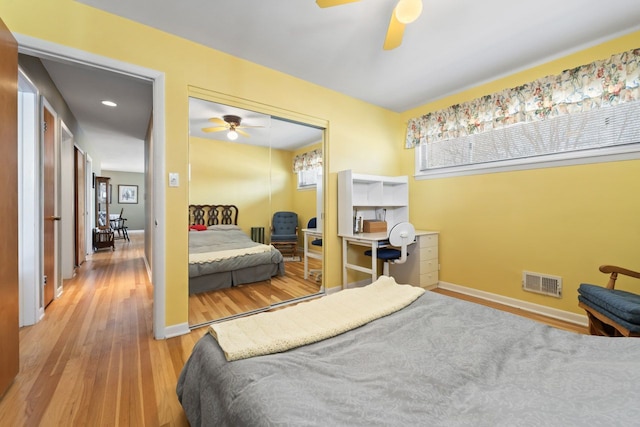 bedroom featuring visible vents, baseboards, wood finished floors, a closet, and a ceiling fan