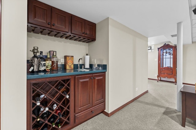 bar with visible vents, light carpet, a sink, wet bar, and baseboards