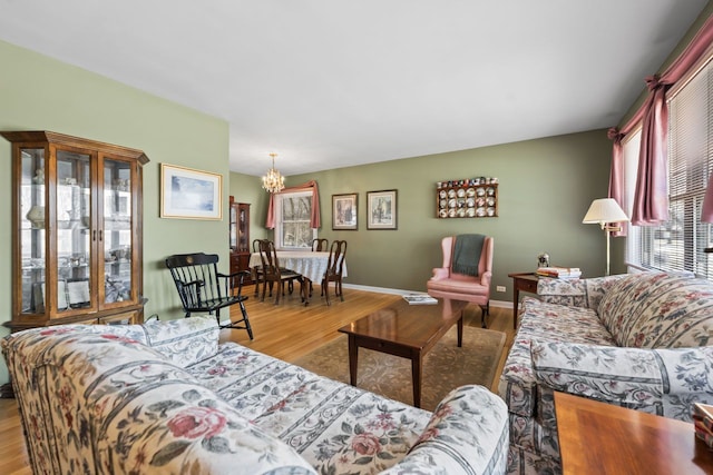 living area with an inviting chandelier, wood finished floors, and baseboards