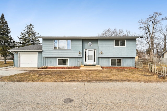 split foyer home with a garage and a front lawn