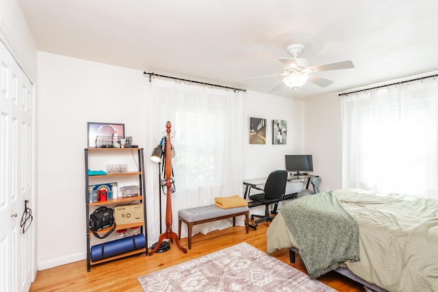 bedroom with ceiling fan, wood-type flooring, and a closet