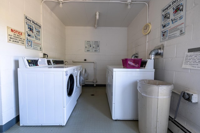 clothes washing area featuring light tile patterned flooring and washer and dryer