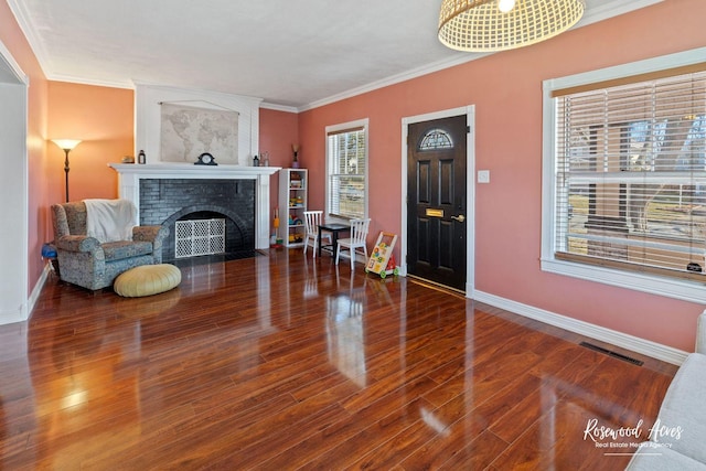 foyer with hardwood / wood-style floors, crown molding, and a fireplace