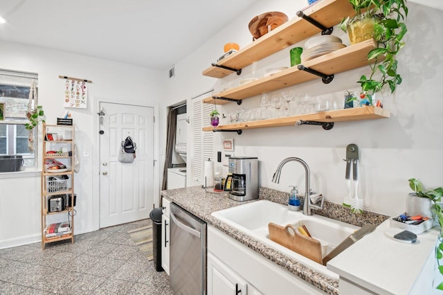 kitchen with dishwasher, open shelves, granite finish floor, and a sink