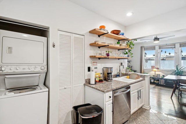 kitchen featuring stacked washer and dryer, stainless steel dishwasher, granite finish floor, a sink, and recessed lighting