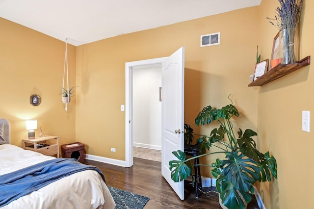 bedroom featuring baseboards, visible vents, and wood finished floors