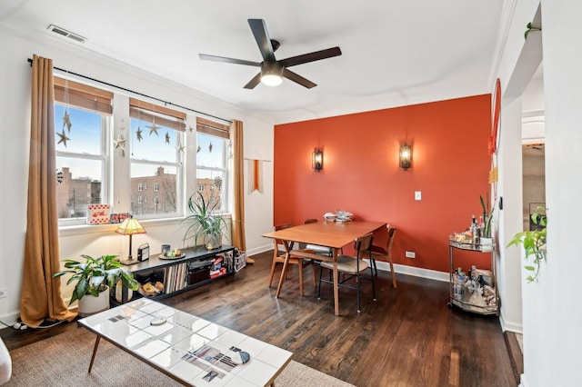 dining room featuring visible vents, ceiling fan, baseboards, and wood finished floors