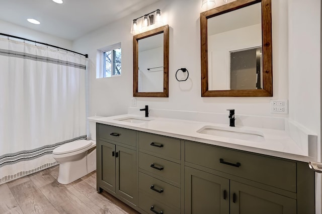 bathroom with walk in shower, wood-type flooring, toilet, and vanity