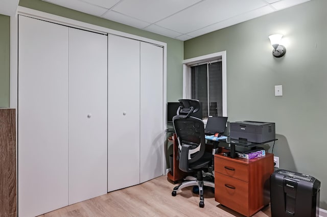 office space with a paneled ceiling and light hardwood / wood-style flooring