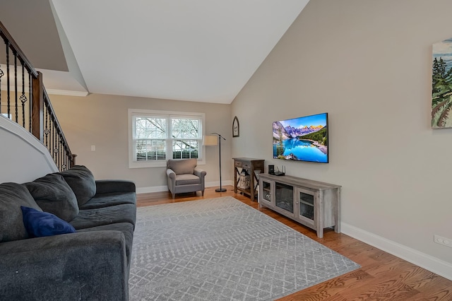 living room with hardwood / wood-style floors and high vaulted ceiling