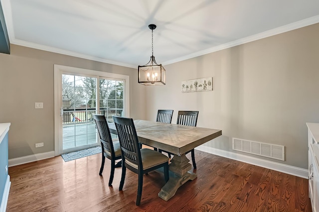 dining room with hardwood / wood-style floors, ornamental molding, and a chandelier