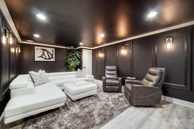 home theater room with wood-type flooring and ornamental molding