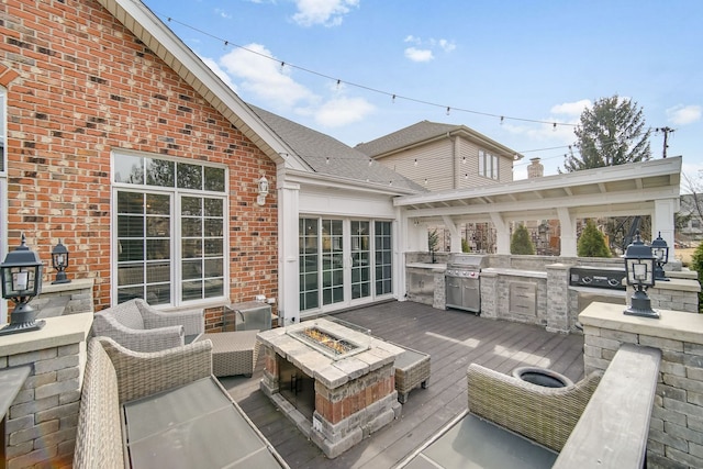 wooden deck featuring area for grilling and an outdoor living space with a fire pit