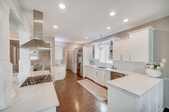 kitchen featuring stainless steel appliances, island range hood, white cabinets, and light stone counters