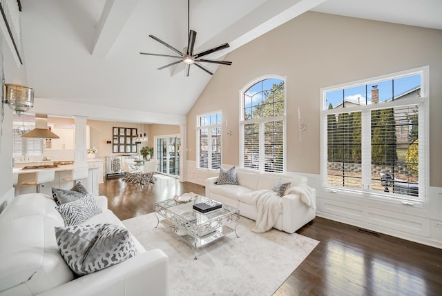 living room with ornate columns, high vaulted ceiling, dark wood-type flooring, and ceiling fan