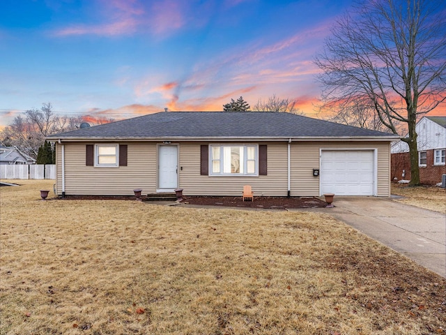 ranch-style house with roof with shingles, concrete driveway, a lawn, an attached garage, and fence