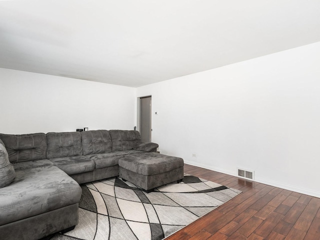 living area featuring visible vents, baseboards, and wood finished floors