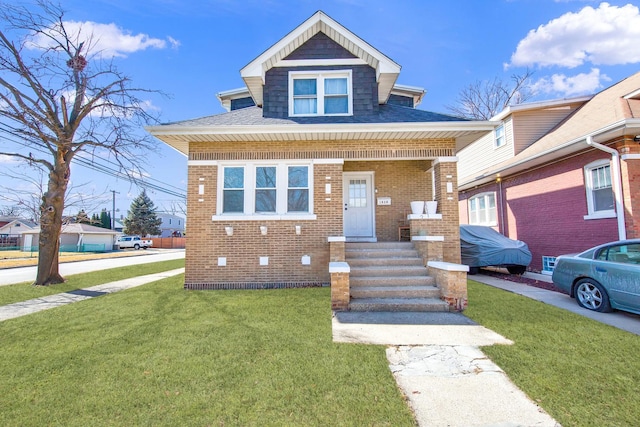 view of front of property featuring brick siding, covered porch, and a front lawn