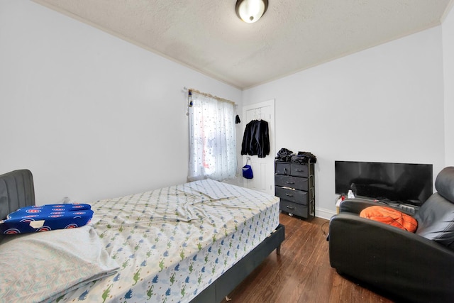 bedroom featuring dark wood finished floors, a textured ceiling, and a closet