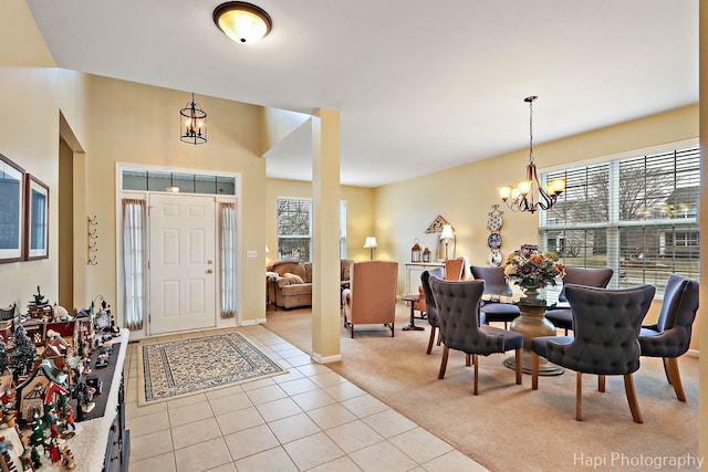 carpeted foyer entrance with an inviting chandelier