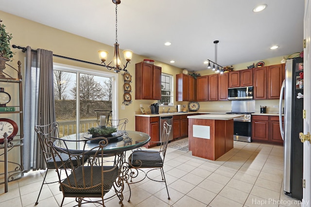 kitchen featuring decorative light fixtures, a center island, light tile patterned floors, a notable chandelier, and stainless steel appliances